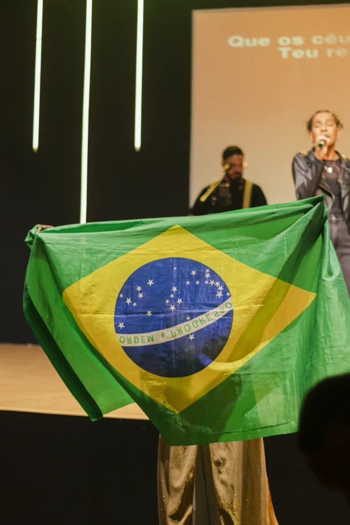 Participante com as mãos levantadas durante a pregação em um culto na MEVAM Campinho.