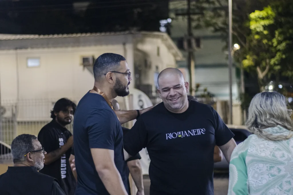 Pessoas conversam e sorriem na área externa da igreja.