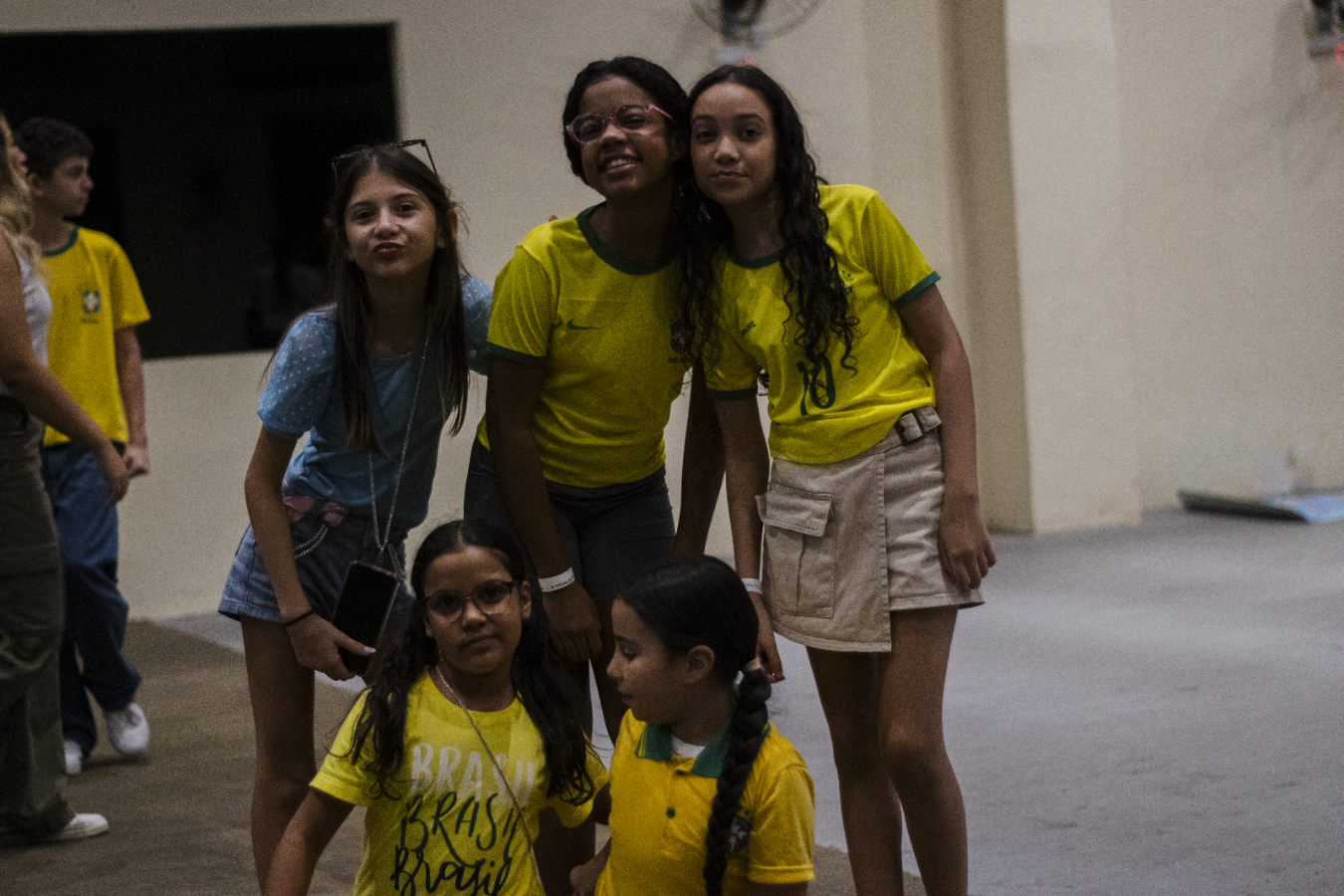 Grupo de participantes reunido na atividade Férias com Deus, com crianças usando camisetas amarelas.